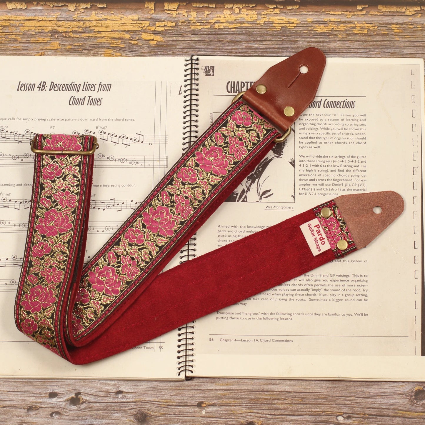 Full view of the Azalea pink floral guitar strap showing the retro pink and gold jacquard pattern with its Burgundy Red suede backing and handcrafted construction.