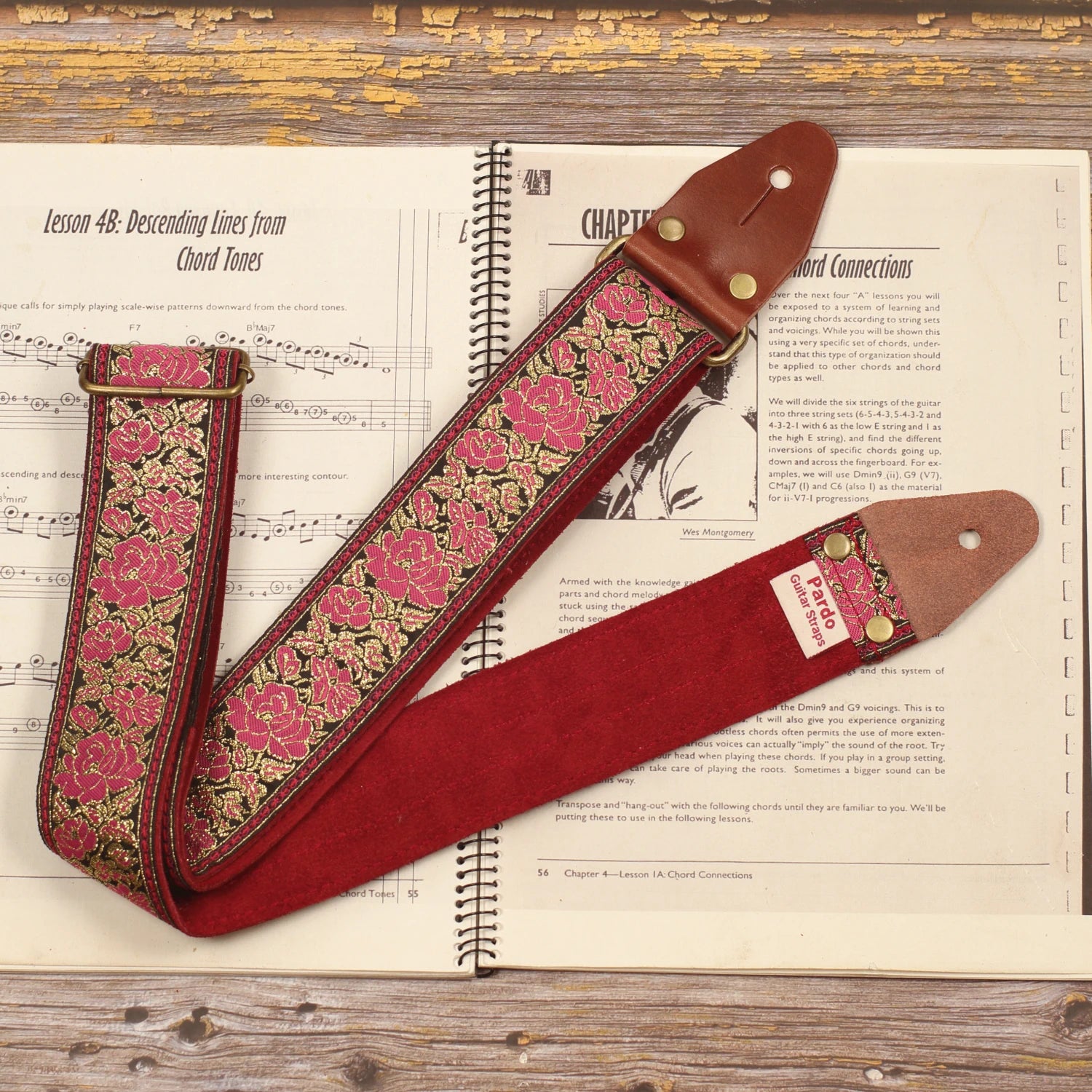Full view of the Azalea pink floral guitar strap showing the retro pink and gold jacquard pattern with its Burgundy Red suede backing and handcrafted construction.