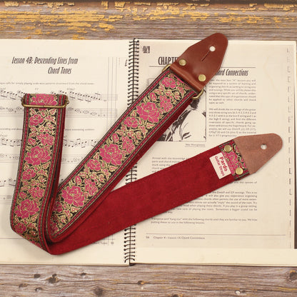 Full view of the Azalea pink floral guitar strap showing the retro pink and gold jacquard pattern with its Burgundy Red suede backing and handcrafted construction.