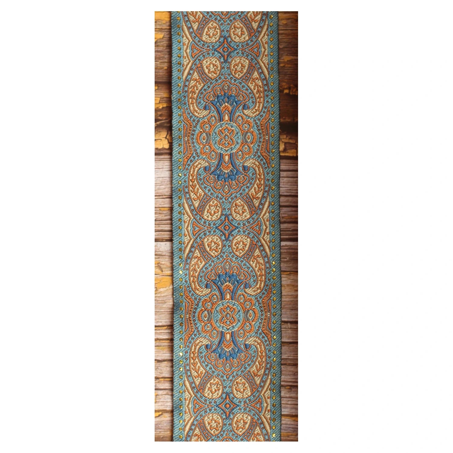 Close-up of the Blusie guitar strap design with symmetrical blue, copper and ivory ornamental details.