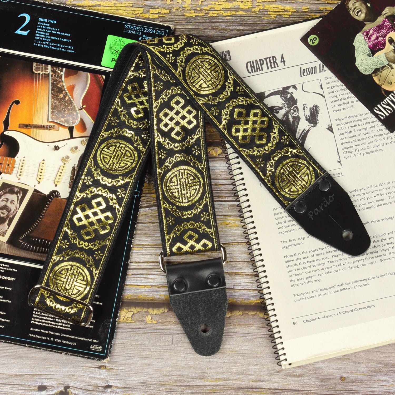 General view of the Medal black and gold guitar strap with shimmering gold jacquard pattern and black genuine leather ends.
