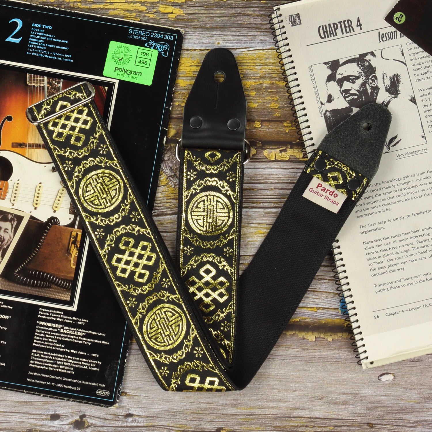 Rear view of the Medal black and gold guitar strap with black seatbelt backing, shimmering jacquard weave and genuine leather ends.