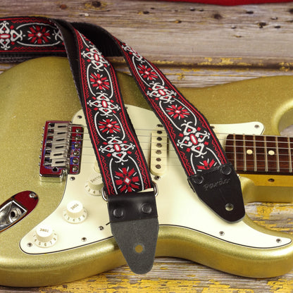 Close-up of the Blackdoor guitar strap on a gold sparkle Fender Stratocaster, showing its woven pattern and black leather ends.