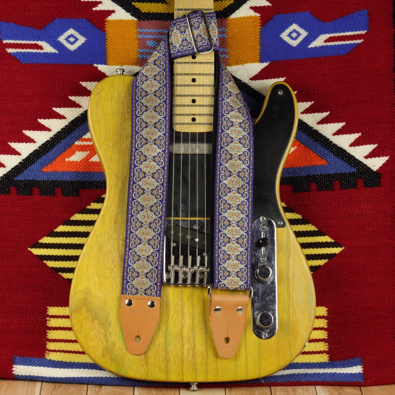 Blue Gothian guitar strap displayed on a Fender Telecaster ’52, showing its blue, ivory and golden woven design.