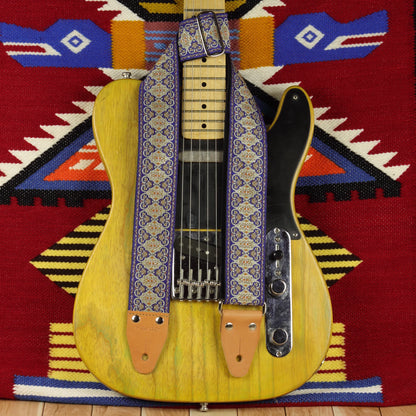 Blue Gothian guitar strap displayed on a Fender Telecaster ’52, showing its blue, ivory and golden woven design.