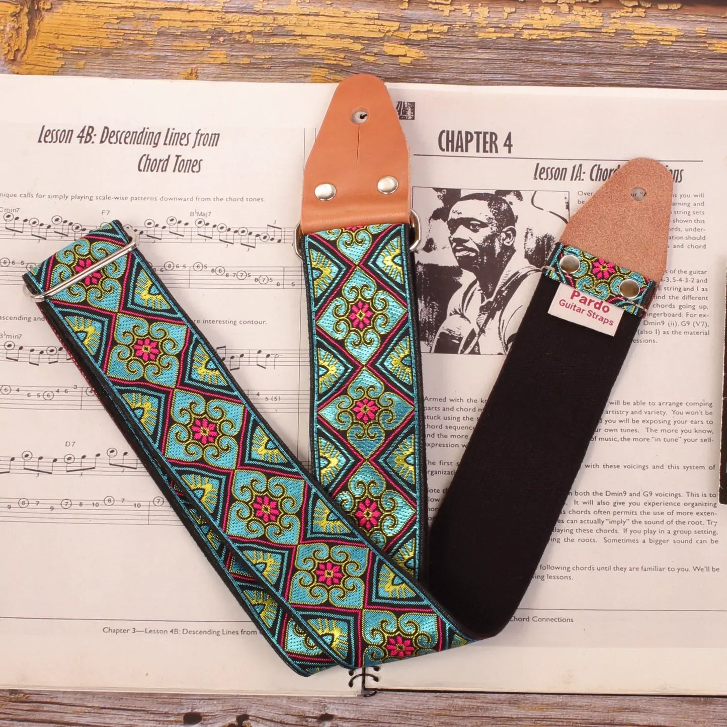 Guitar strap made with a woven jacquard fabric with color blue and small red flowers