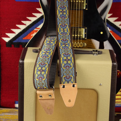 Blue lake guitar strap displayed with a Fender Champion 600 amplifier and electric guitar in the background.