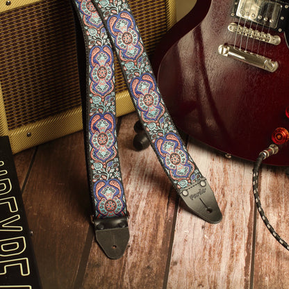 Blue Mirage handmade guitar strap displayed with a Gibson SG and Fender Champ amplifier in a studio setting