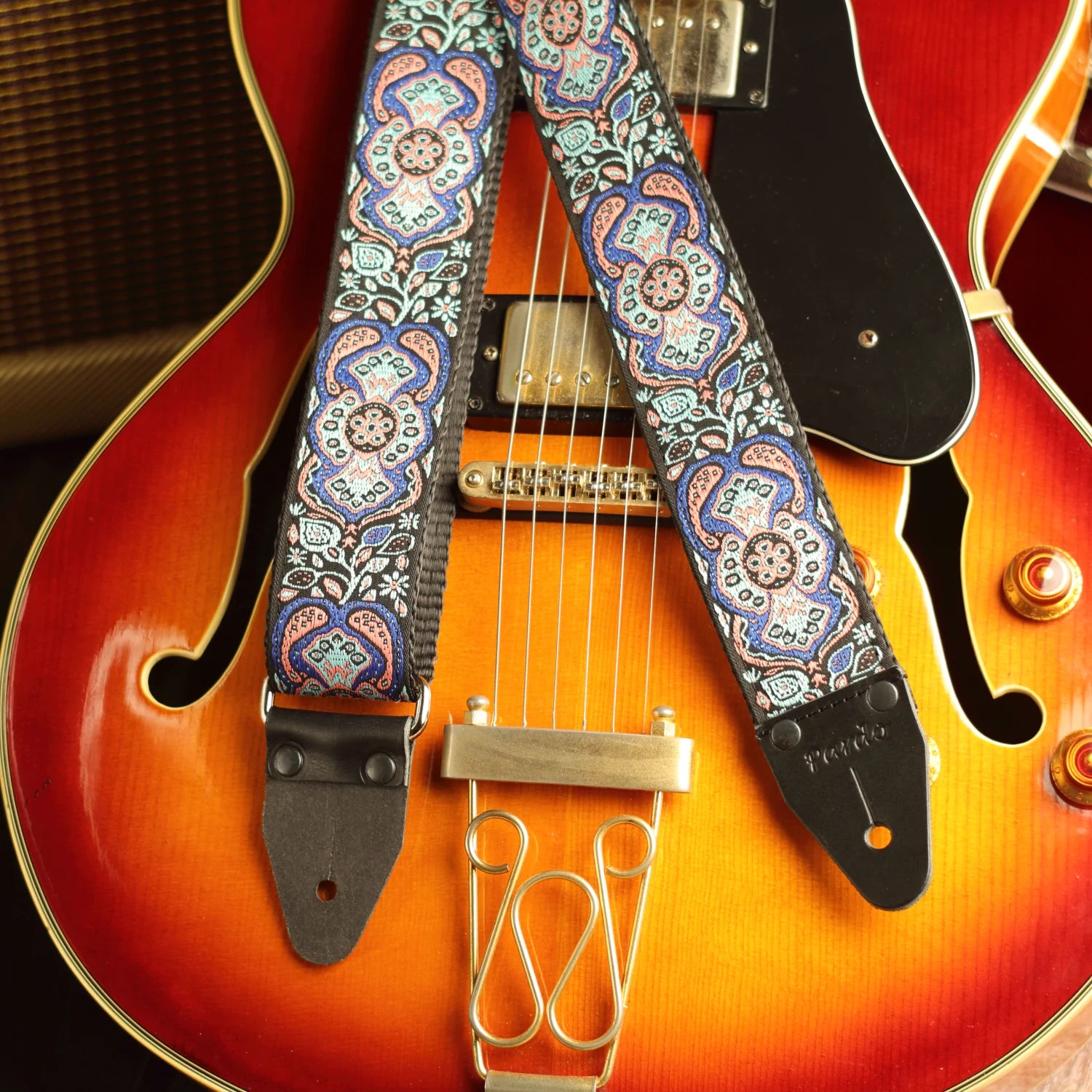 Blue Mirage handmade guitar strap displayed with a hollow-body jazz guitar, highlighting its premium jacquard pattern
