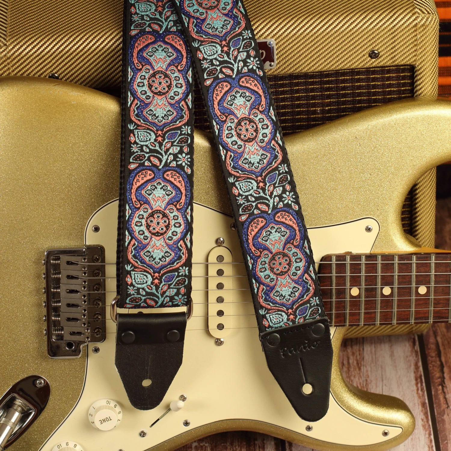 Blue Mirage handmade guitar strap close-up featuring premium jacquard fabric and genuine leather ends paired with a Gold Sparkle Fender Stratocaster