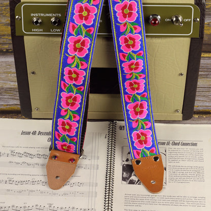 Blue Serenade guitar strap displayed with a Fender Champion 600 amplifier and a sheet music book.