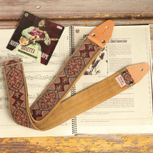 Brown Mountain psychedelic jacquard guitar strap with earth-tone vintage pattern displayed on an open guitar chord book beside a Sister Rosetta Tharpe album cover. Handmade artisan guitar strap with suede backing.