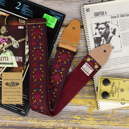 Burgundy Pheasant guitar strap showing its jacquard pattern, red burgundy suede backing and light brown leather ends