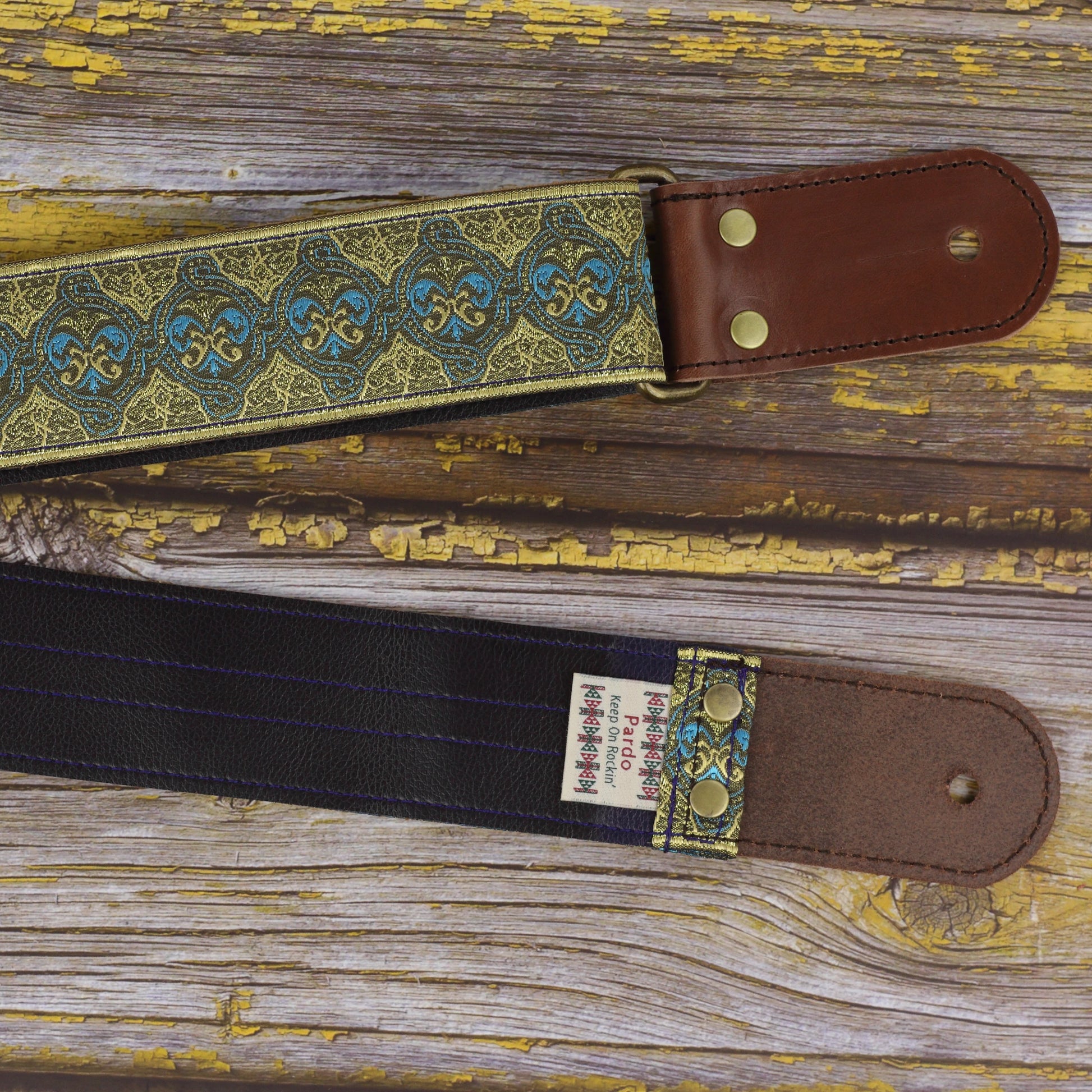 Close view of the Dune guitar strap with dark brown round leather ends, jacquard fabric and Dark Blue Vinyl backing.