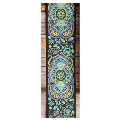 Close-up of the Blue Paisley guitar strap design with large turquoise, pale yellow and lavender motifs against a black background.