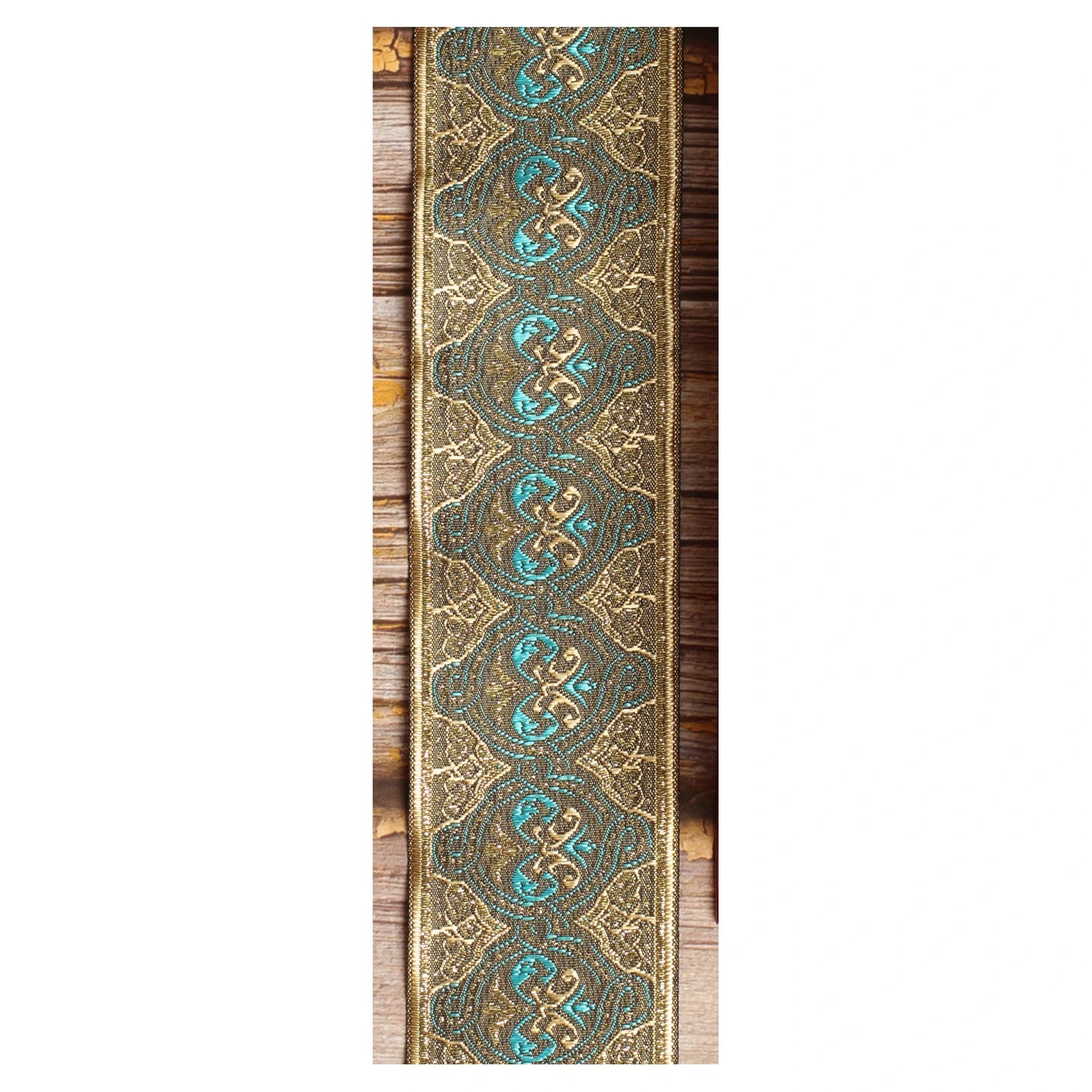Close-up of the Dune guitar strap design with repeating turquoise loops, bronze tones and finely detailed golden lines.