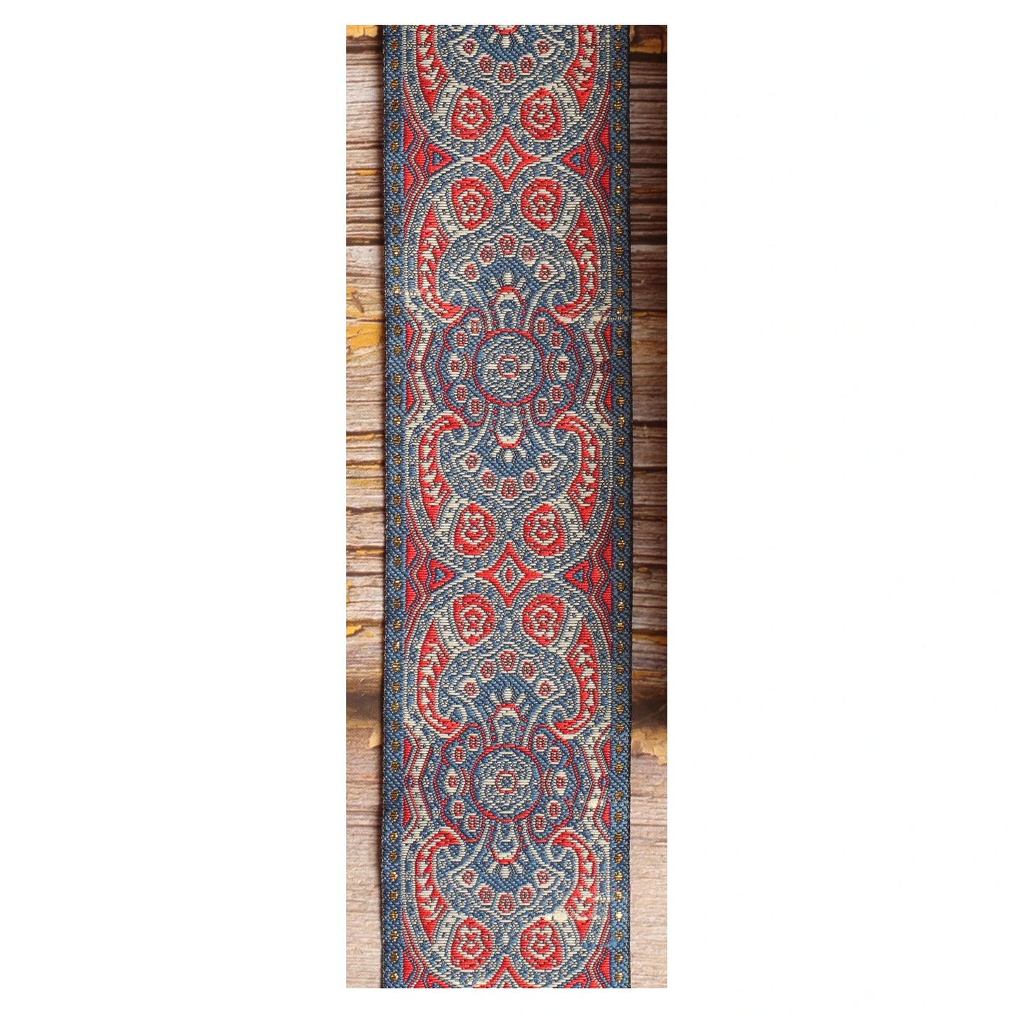 Close-up of the Efrit guitar strap design featuring symmetrical red, ivory and slate blue medallions and ornamental details.