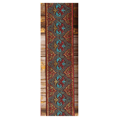 Close-up of the Pilgrim guitar strap design with interlocking turquoise and red forms, golden details and deep red borders.