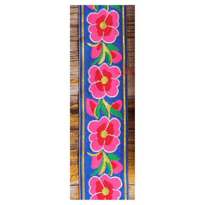Close-up of the Blue Serenade guitar strap design with large pink and red motifs and green leaves against a rich blue background.