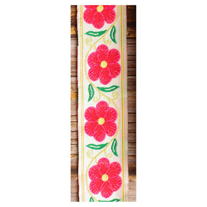 Close-up of the Ivory Garland guitar strap design with large red and pink motifs, green leaves and golden details on an ivory background.