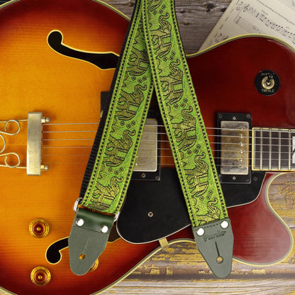 Green and gold elephant jacquard guitar strap displayed on an Aria Pro II FA-70 hollow body jazz guitar