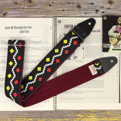 George Harrison model Diamonds guitar strap with black jacquard fabric and red/yellow diamonds, shown with a suede backing.