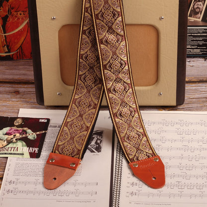 Hippie strap model Brown mountain, with extra wide 2'5 inches, displayed next to a guitar amplifier Fender Champion 600