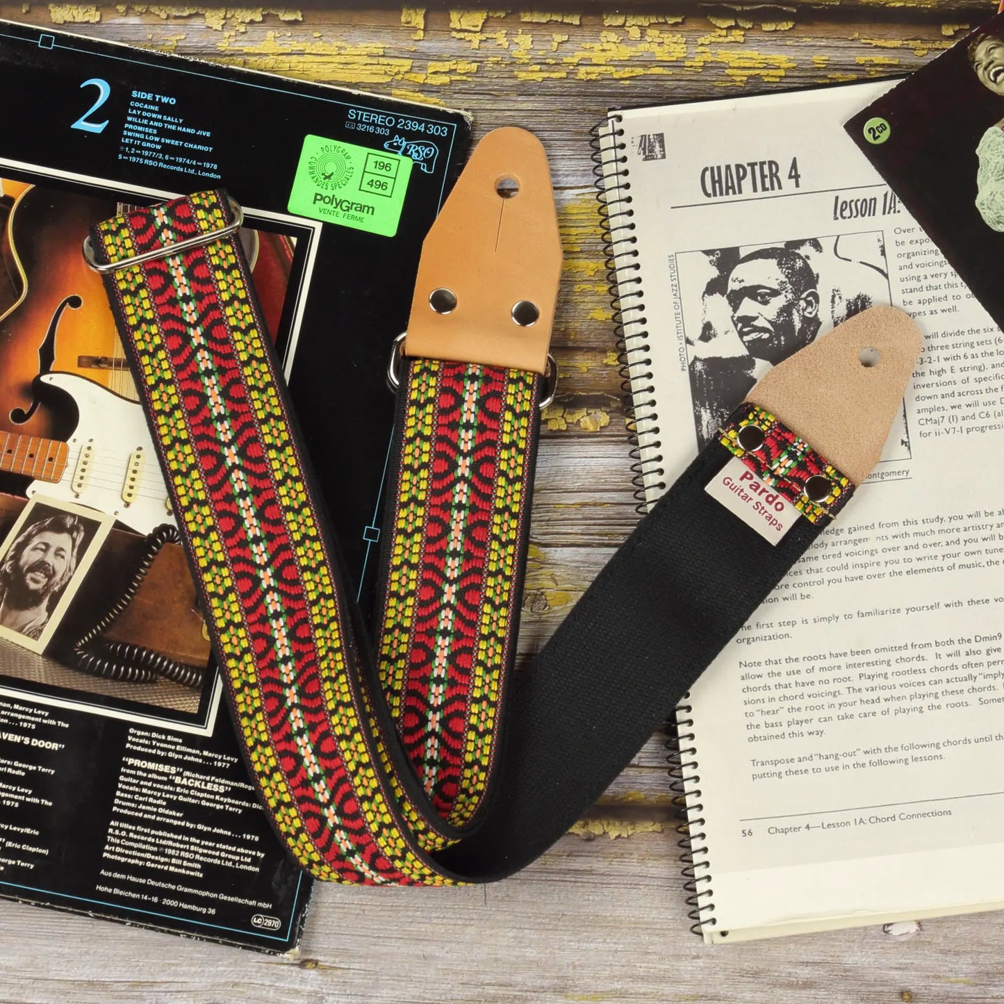 Hootenanny guitar strap bohemian style inspired in 60s hippie patterns, frontview showing the leather ends parts, metal hardware and backing seatbelt color black