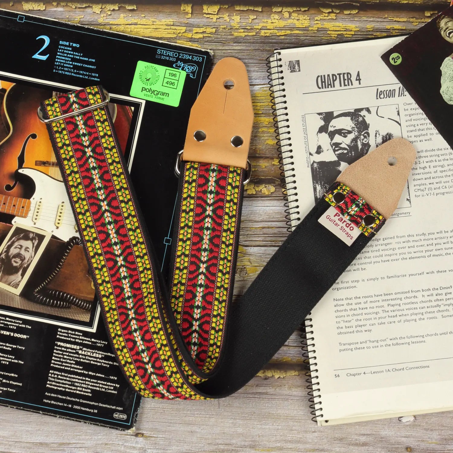 Hootennany guitar strap bohemian style inspired in 60s hippie patterns, frontview showing the leather ends parts, metal hardware and backing seatbelt color black