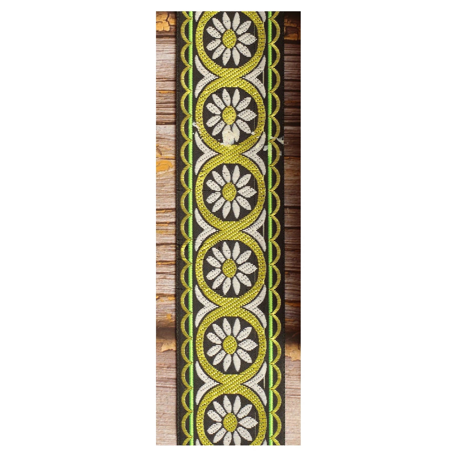 Meadow Echo woven guitar strap featuring delicate white botanical motifs against a green background.