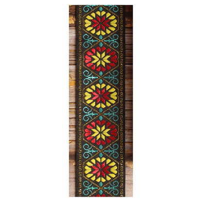 Midnight Carnival woven guitar strap featuring multicolored botanical motifs against a black background.