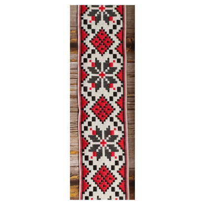 Close-up of the Crimson Compass guitar strap design with symmetrical red and black geometric motifs on an ivory background.