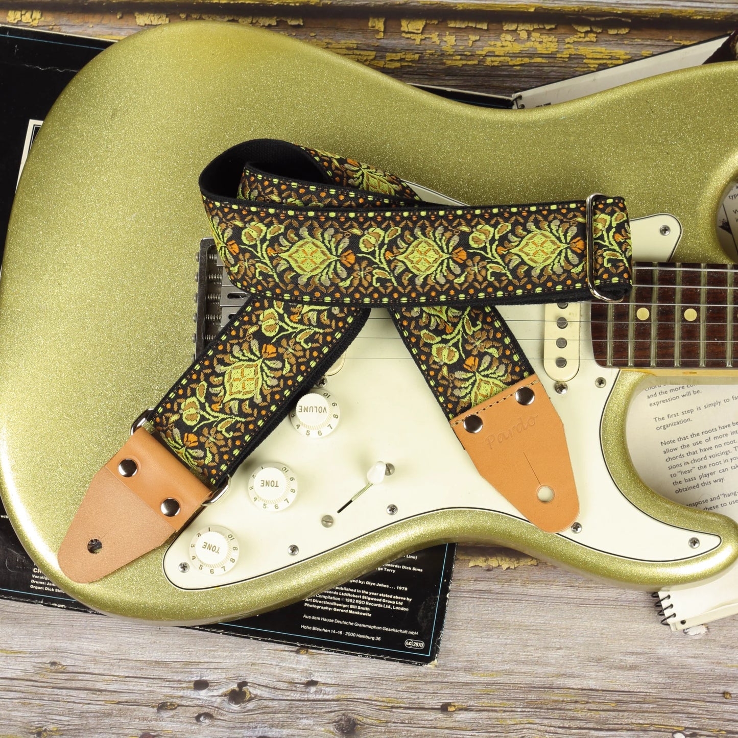 Ochre Pheasant guitar strap displayed on a Gold Sparkle Fender Stratocaster with complementary warm tones