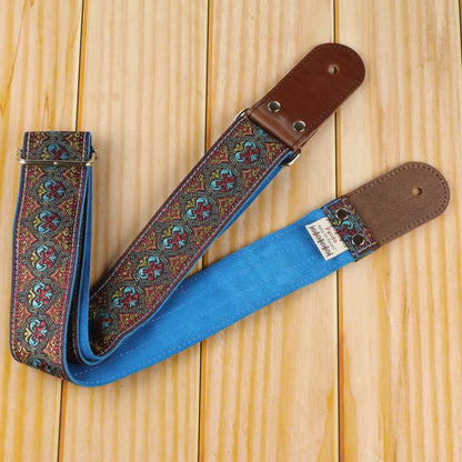 General view of the Pilgrim guitar strap showing its jacquard pattern, Blue Turquoise suede backing and dark brown round leather ends.