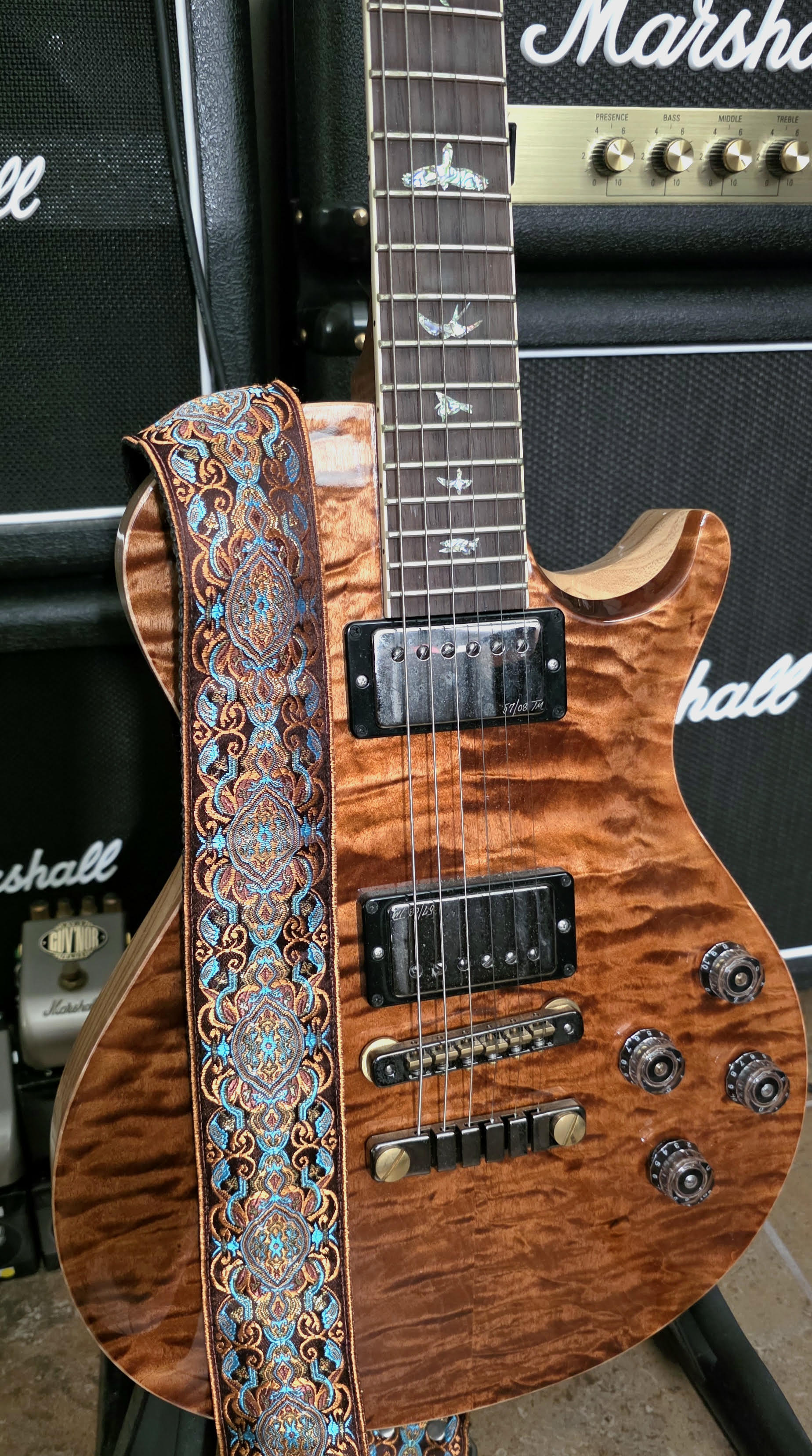 PRS McCarty 594 Singlecut featuring hand-selected Wood Library figuring, displayed with a patterned Pardo guitar strap.