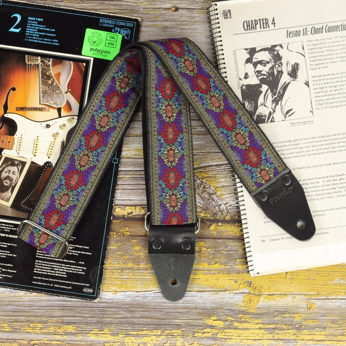 Front view of the Purple Frame guitar strap showing its detailed jacquard fabric and black leather ends.