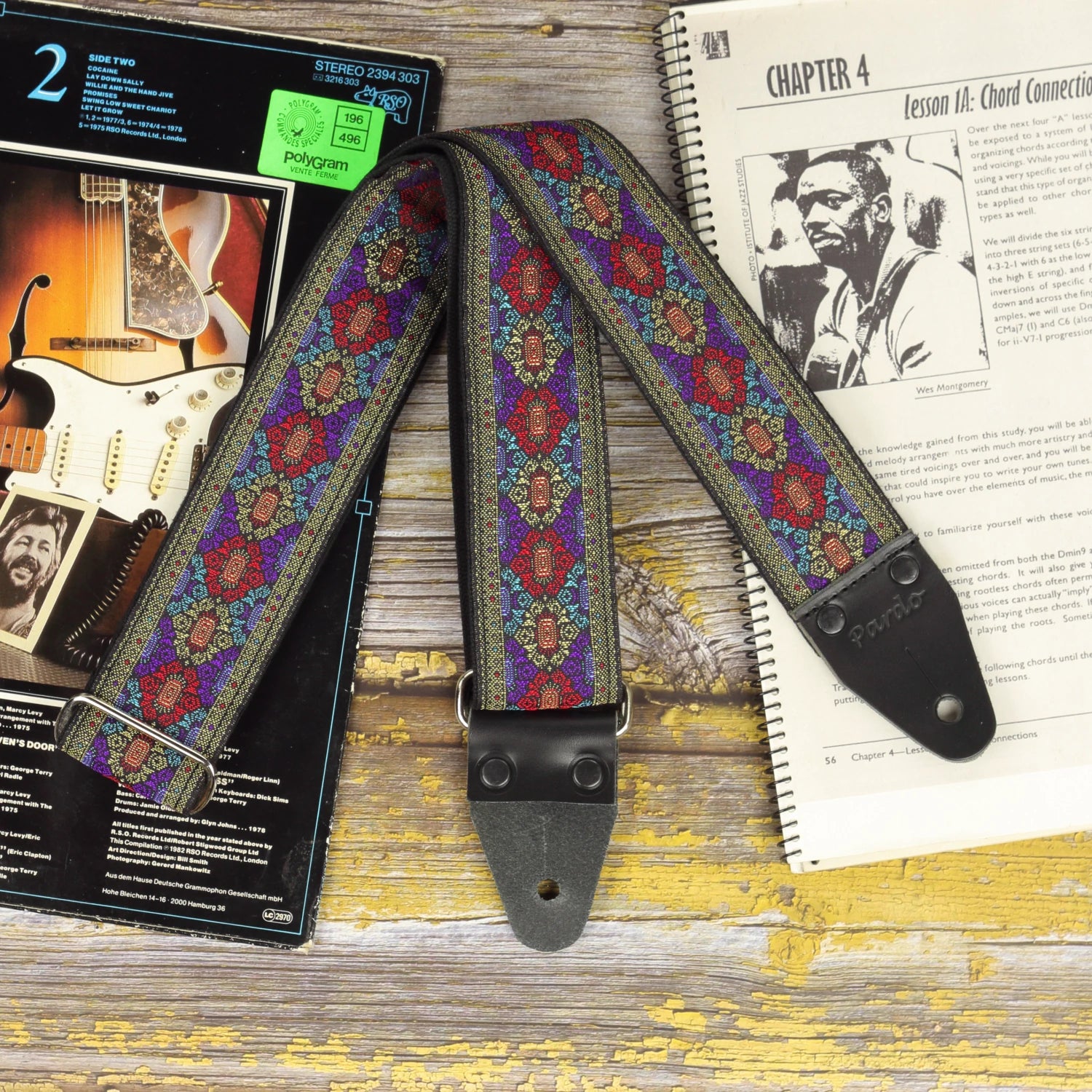 Front view of the Purple Frame guitar strap showing its detailed jacquard fabric and black leather ends.