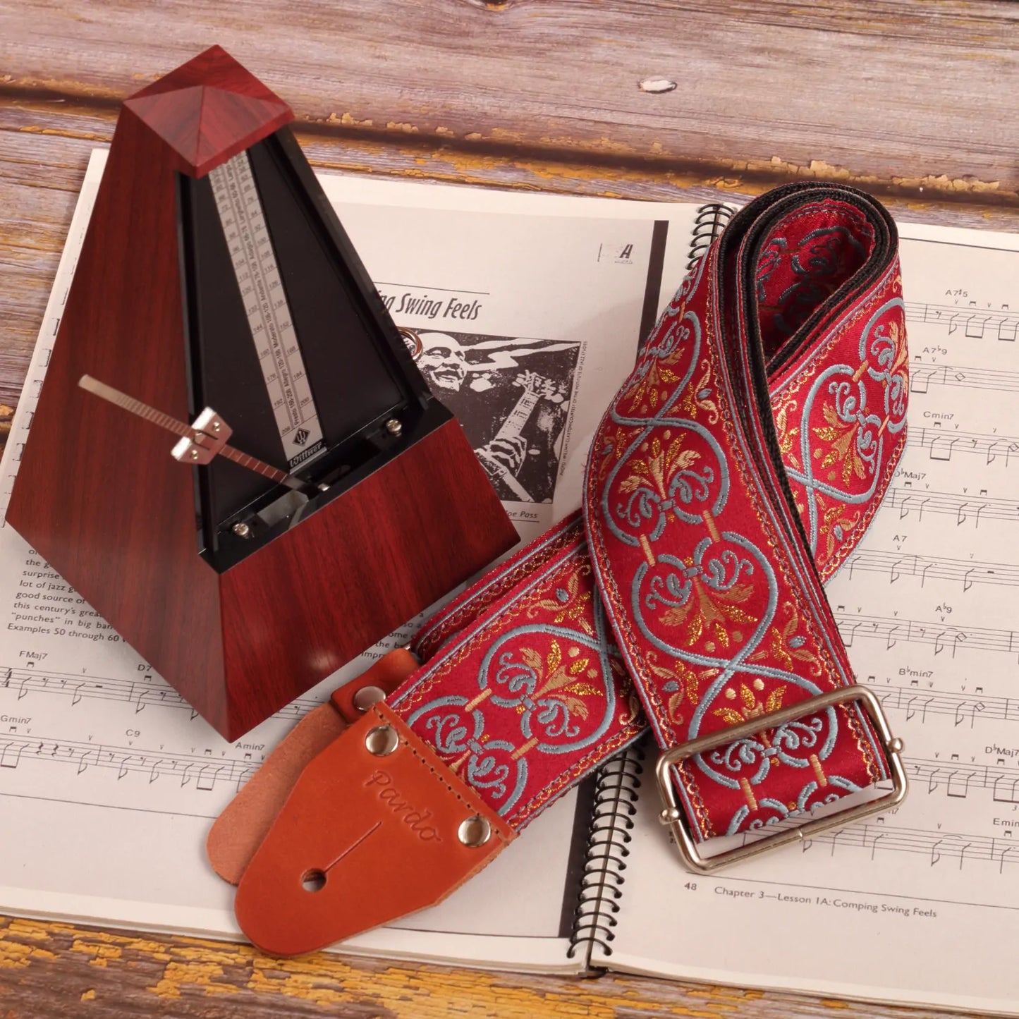 Lifestyle photo emphasizing longevity and premium quality. Strap paired with a metronome, ideal for guitar lovers and music students