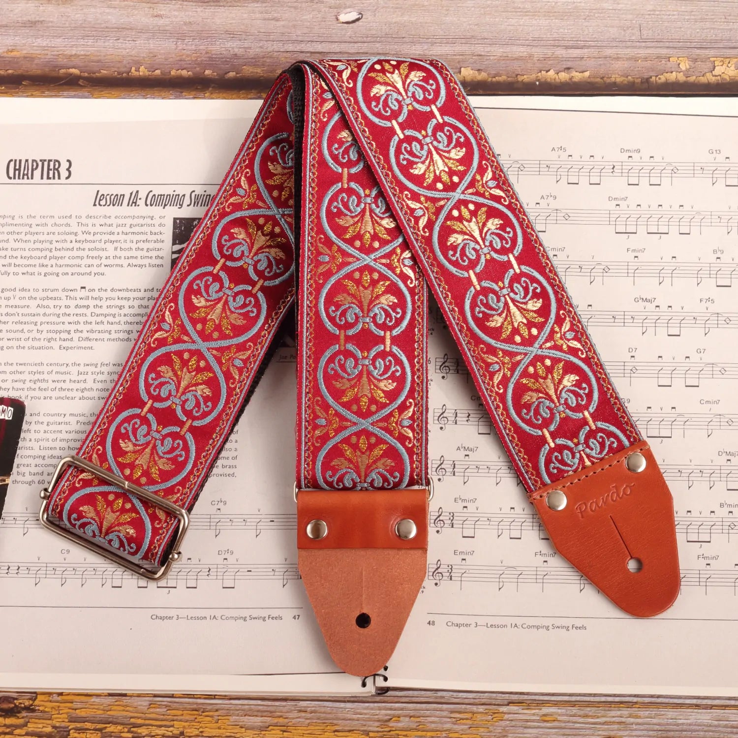 Front view of the red jacquard guitar strap with blue intricate  laces 