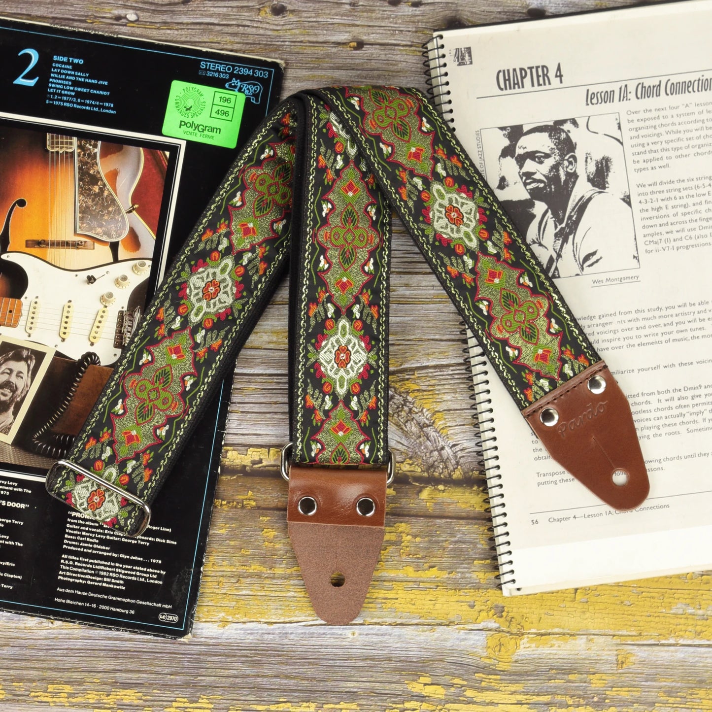 Front view of the Red Fly guitar strap showing its woven design and dark brown leather ends.