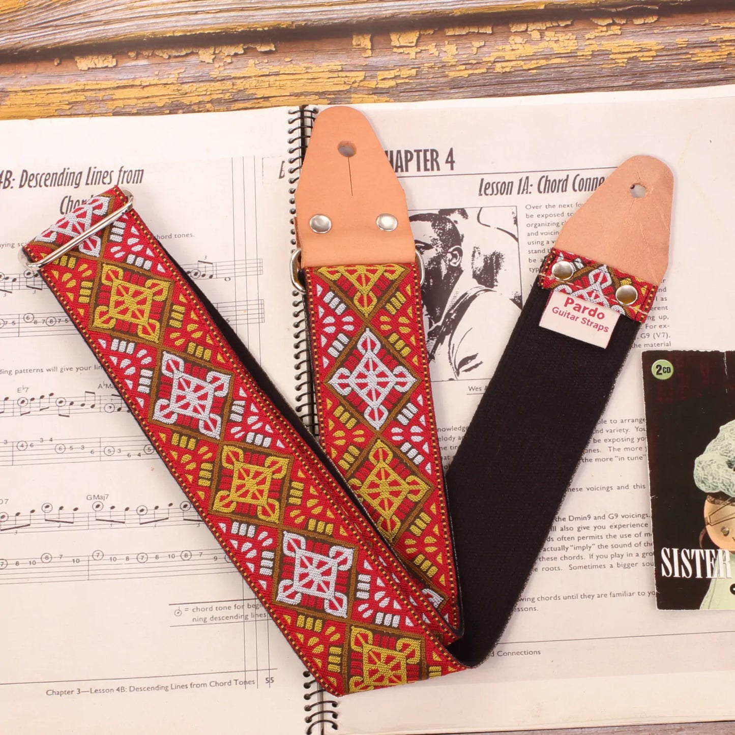 Guitar strap made with a jacquard fabric with baroque and bohemian style, with red colors, white and ocre