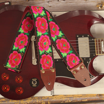 Rose-pattern guitar strap displayed on a cherry red Edwards SG-style guitar