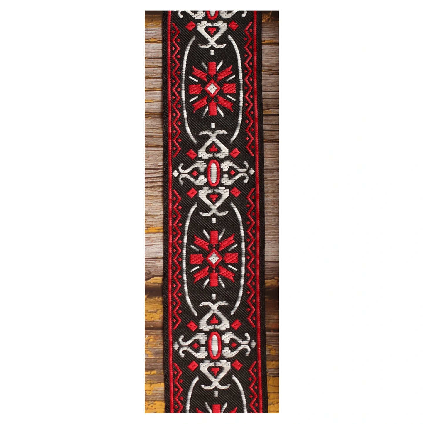 Close-up of the Blackdoor guitar strap design with repeated red and white geometric motifs against a black background.