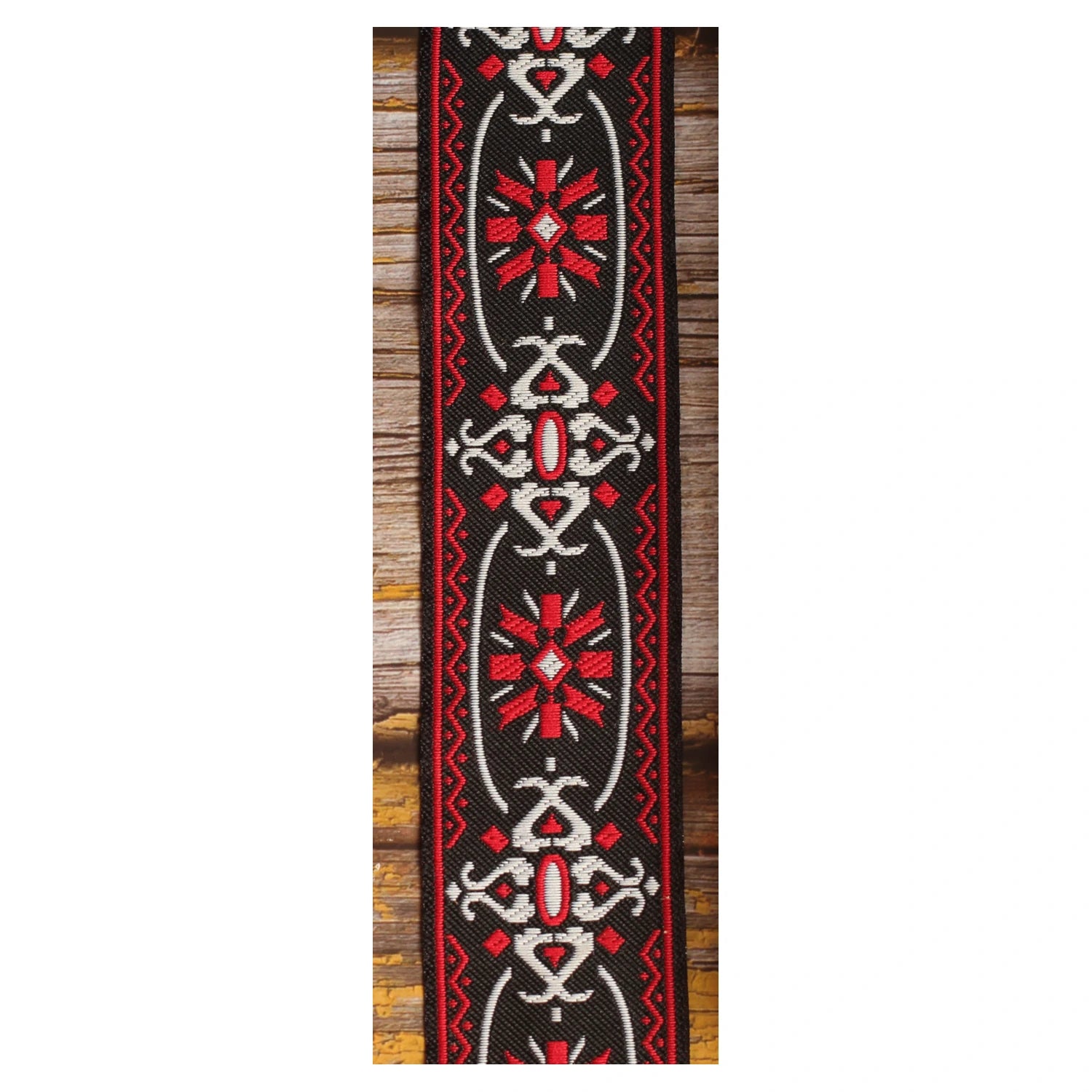 Close-up of the Blackdoor guitar strap design with repeated red and white geometric motifs against a black background.