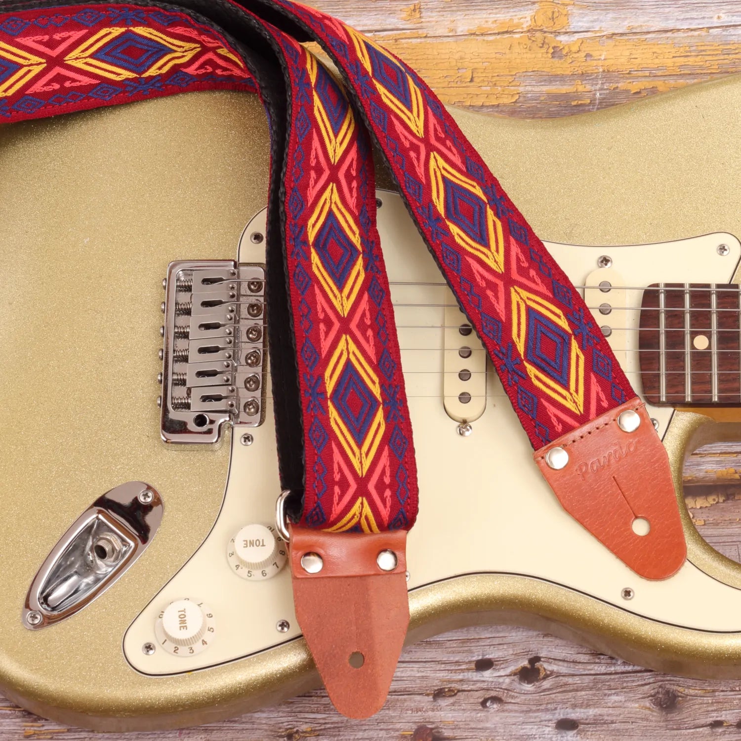 Tribal inspired Red Chief guitar strap in bold colors paired with a Fender Stratocaster Gold Sparkle