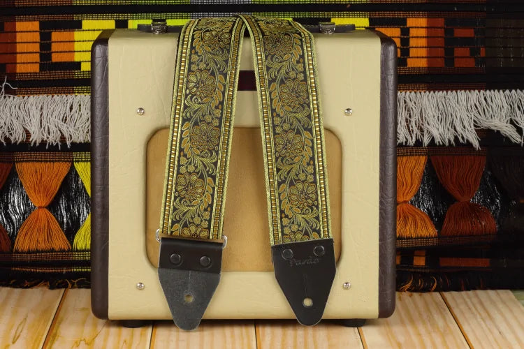 Comfortable 2.5-inch wide guitar strap with ochre-gold floral motifs and a classic hippie aesthetic.