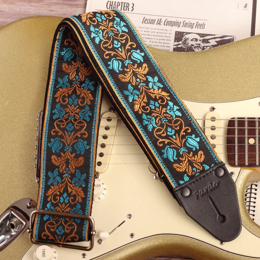 wide long floral jacquard guitar strap in blue and ochre on black with Fender Stratocaster Gold Sparkle